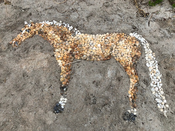 Horse made of shells in sand